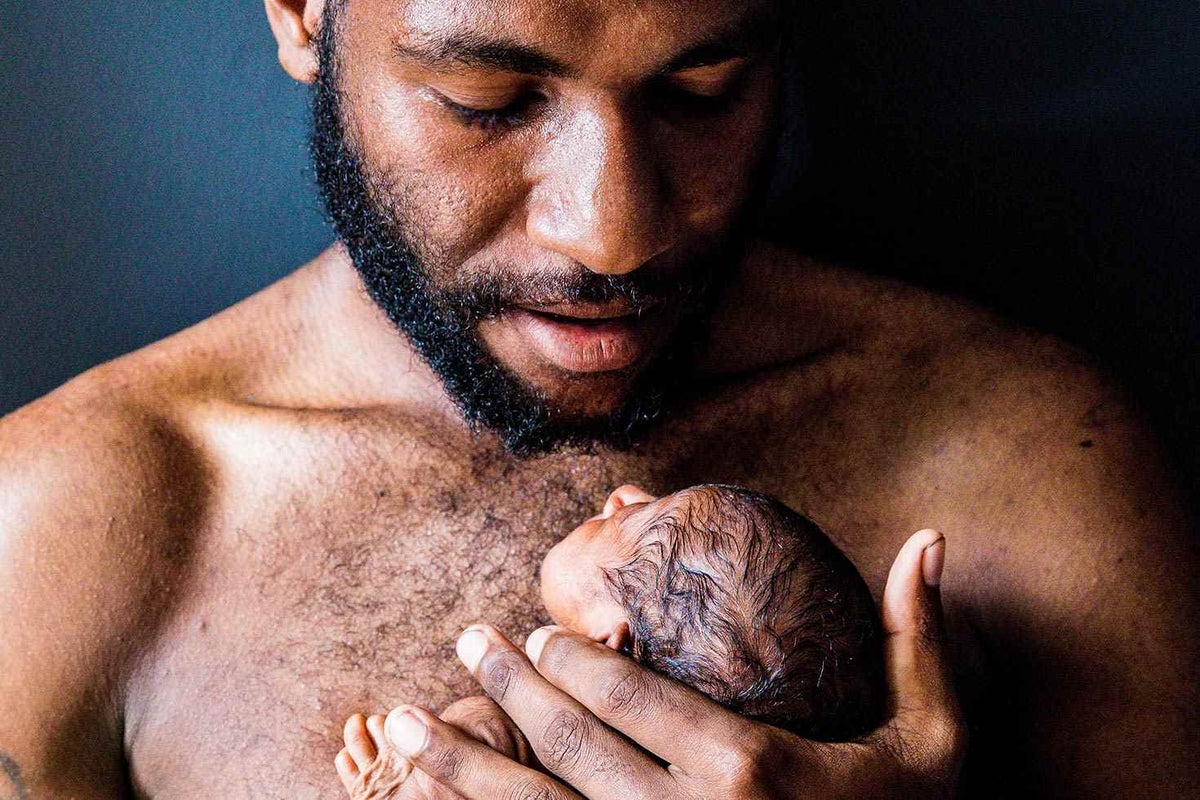 Ikia Thomas holds one of his new-born premature twins. The child is one month old and is not yet named. 