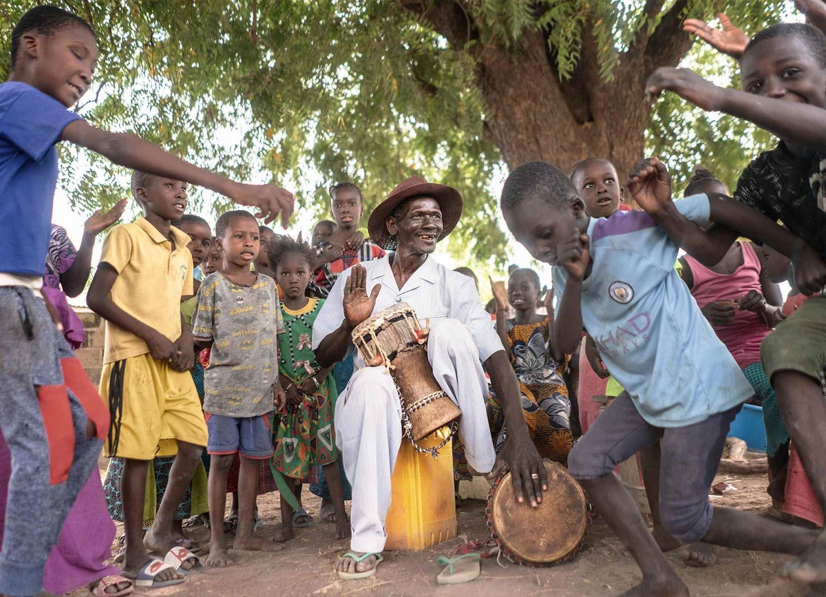 Takatiti, a town crier and community mobiliser, informs people via music about the polio vaccination campaign in The Gambia.