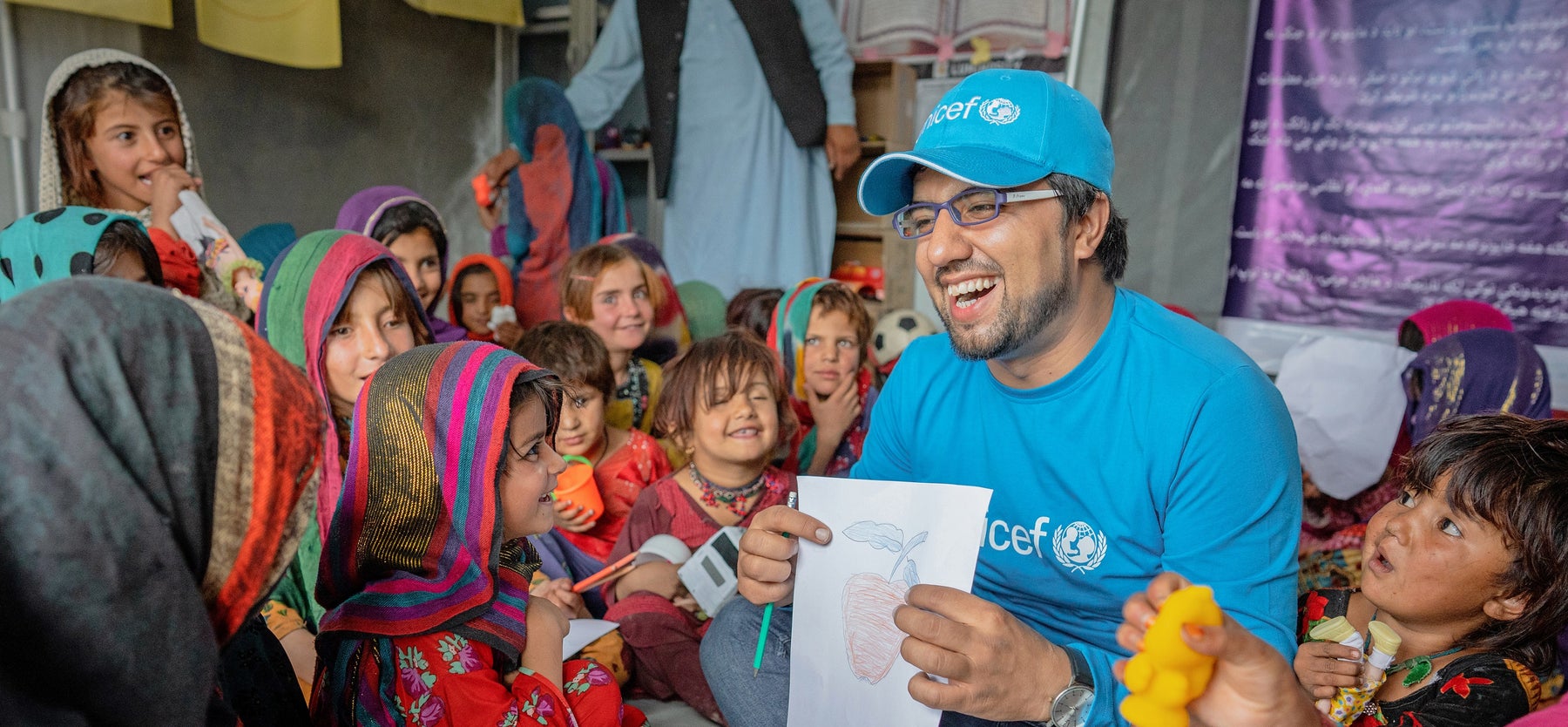 UNICEF worker showing a picture to children