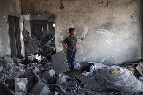 A young boy in Gaza assesses the damage caused by recent airstrikes. 