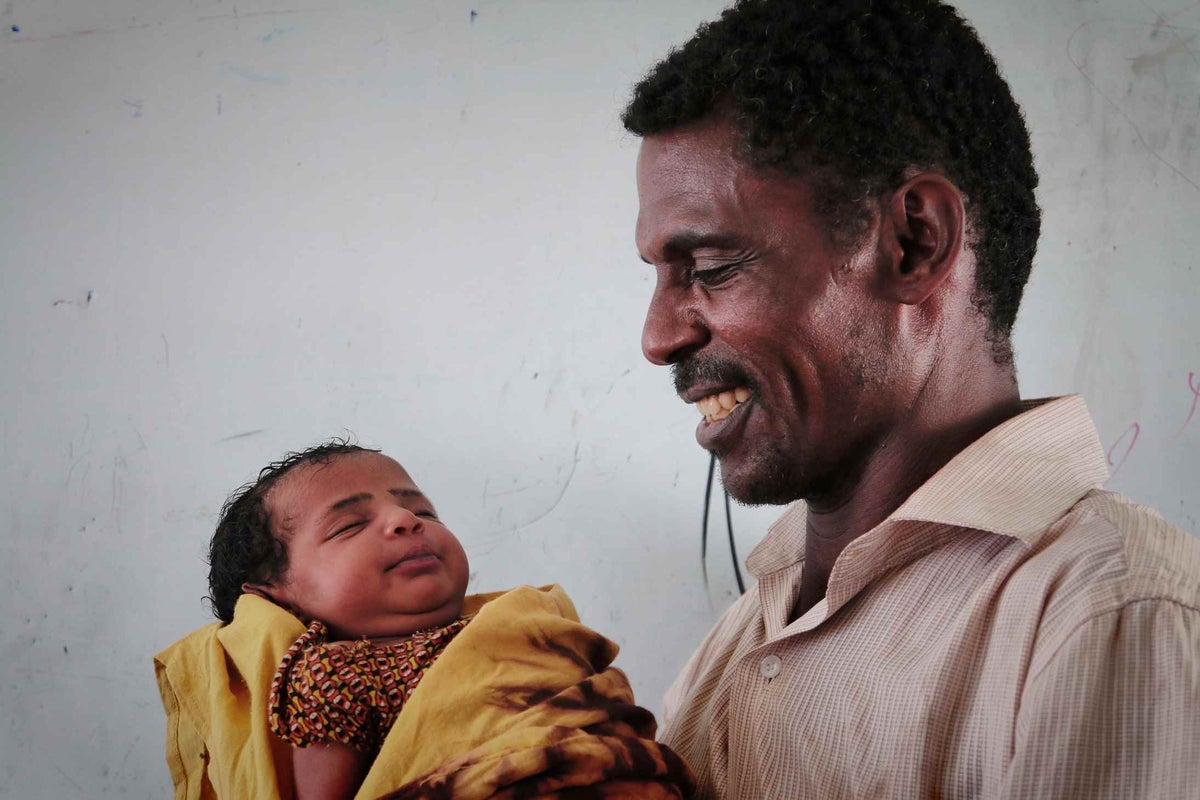 Happy father Abo holds Aisha, his newborn daughter.