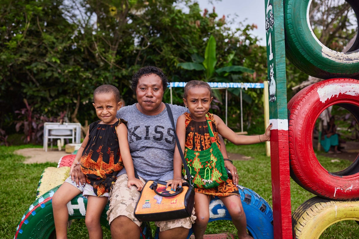 Linda sits with her children, five-year-old Phillandray and six-year-old Phillandrah in their school’s playground.  