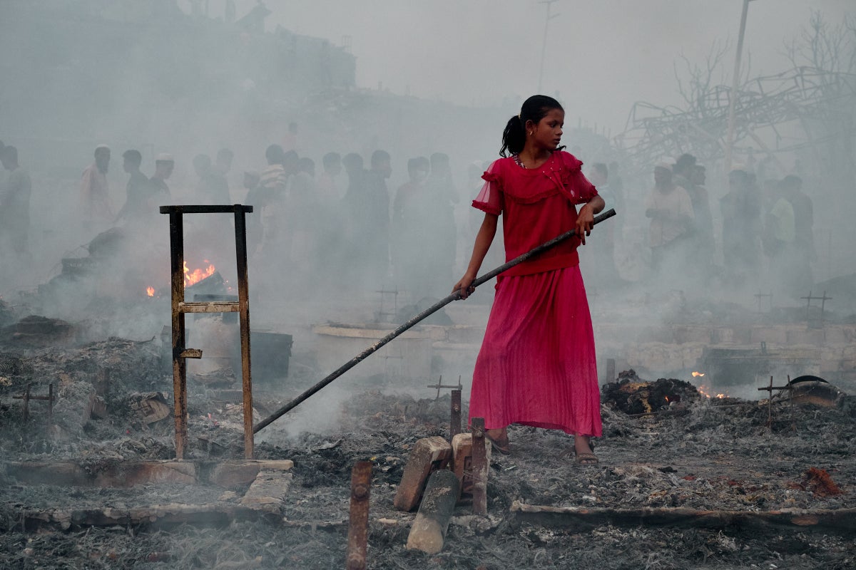 A child searches for belongings in the ruins left by a fire in Cox’s Bazar, the world’s largest refugee settlement.