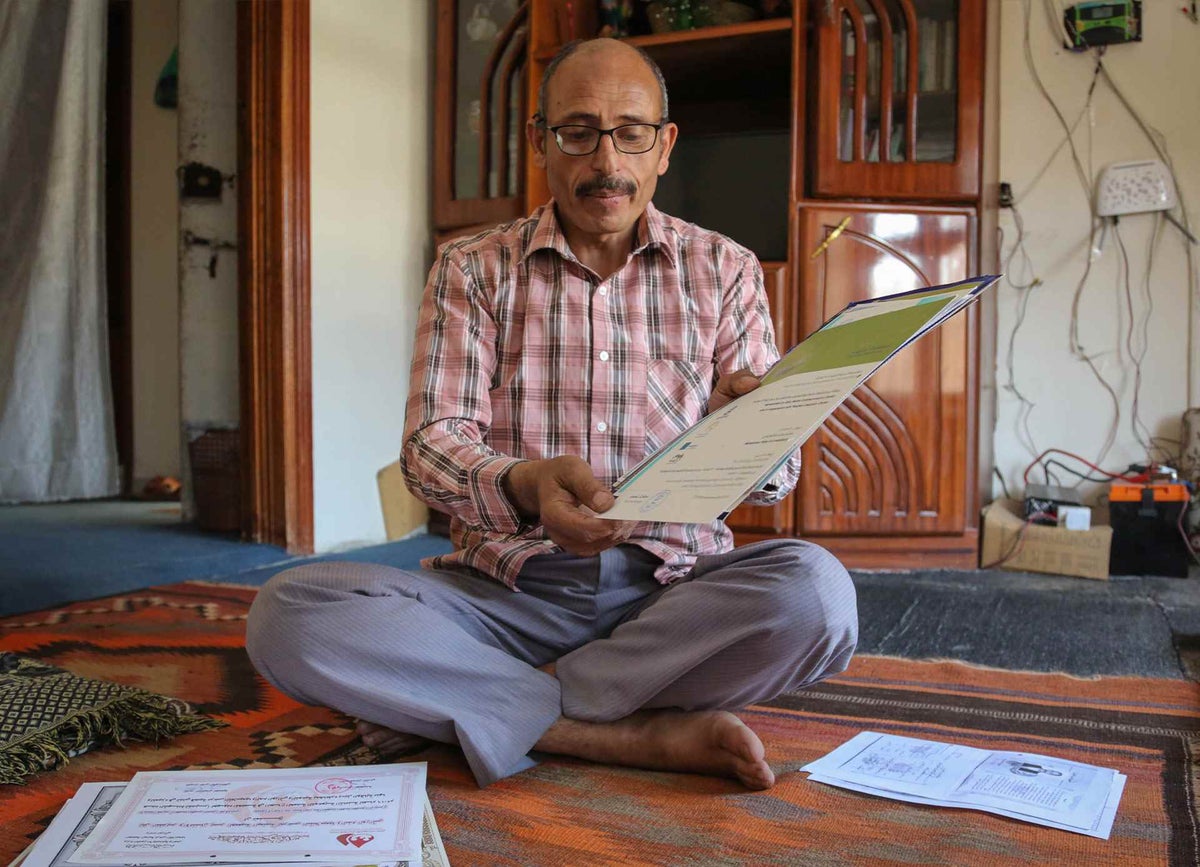 Man sitting on floor with certificate.