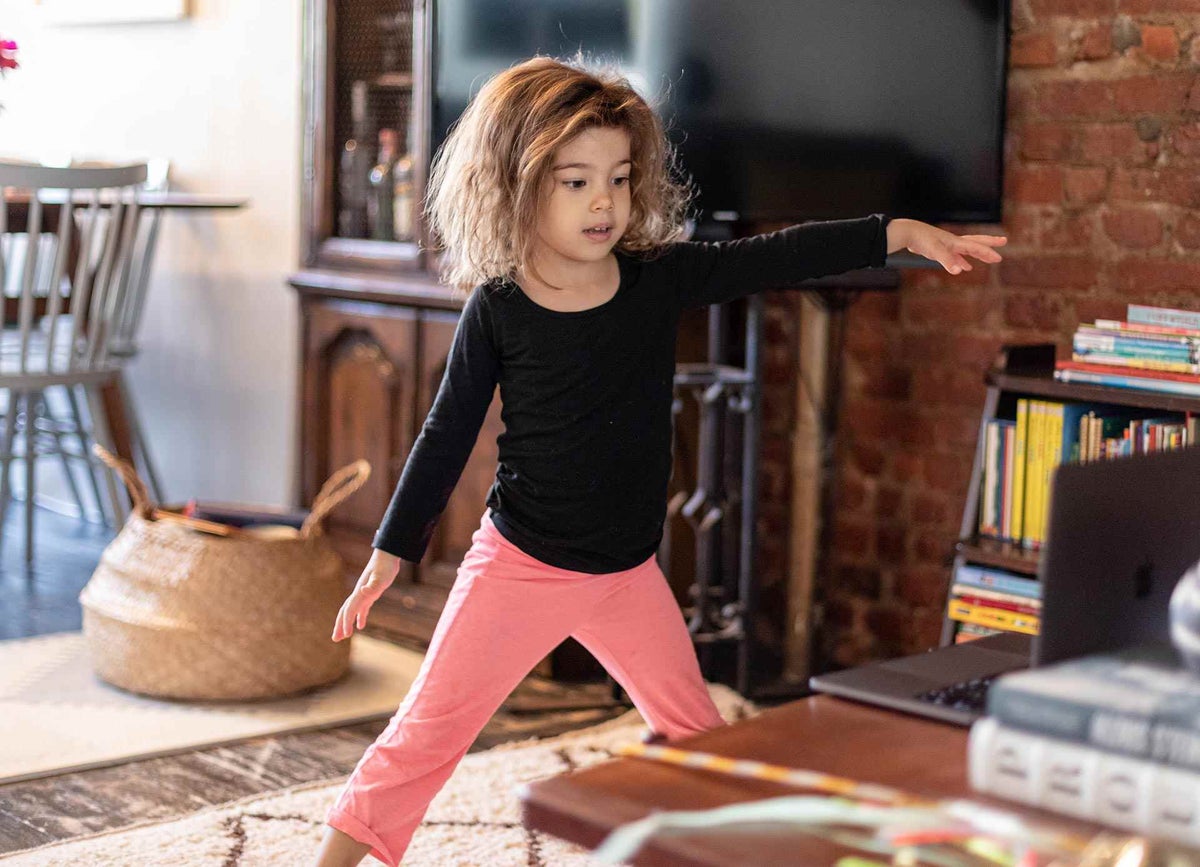 Margot, 4, does a yoga class as she would do every week in daycare, at home.