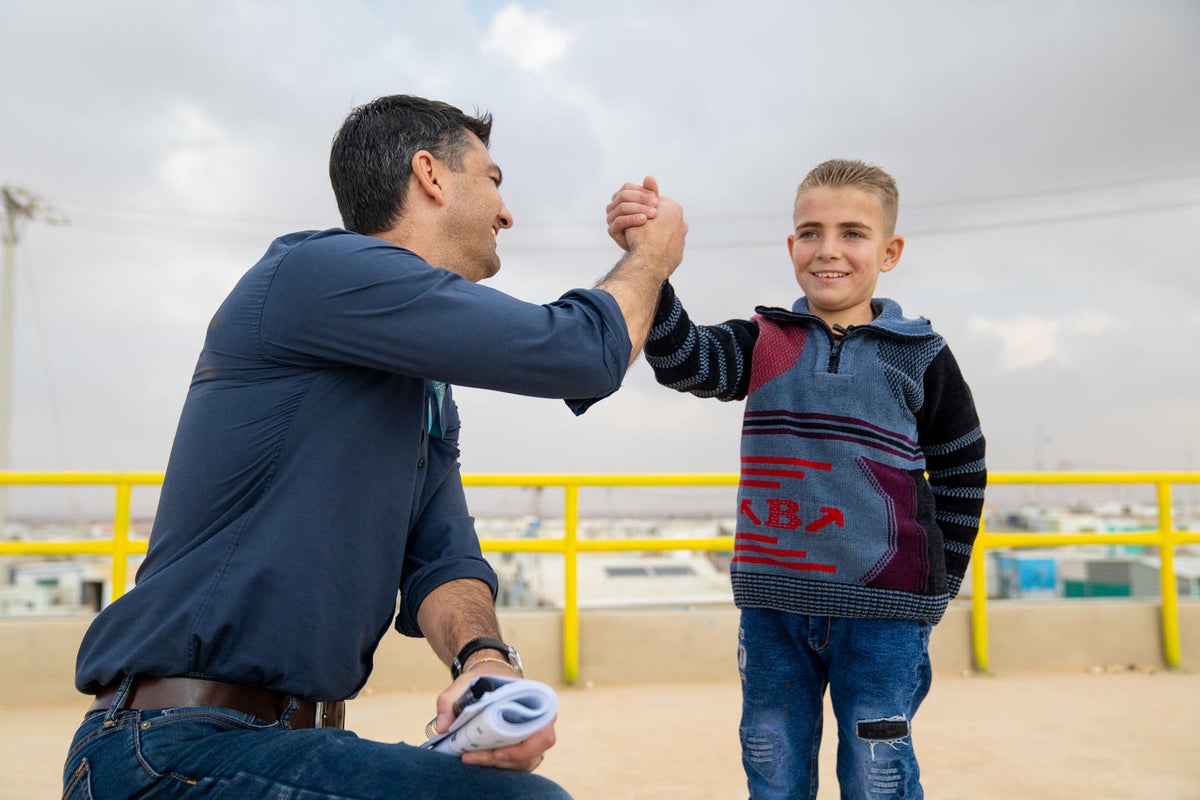 A man and a boy are doing a high five.