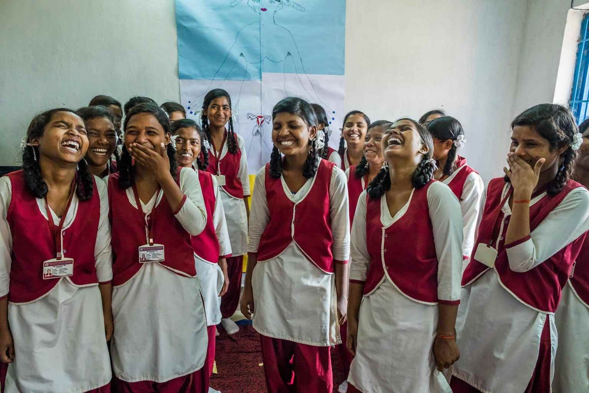 Adolescent girls react while they participate in a body-mapping activity where they talk about menstruation openly during a session