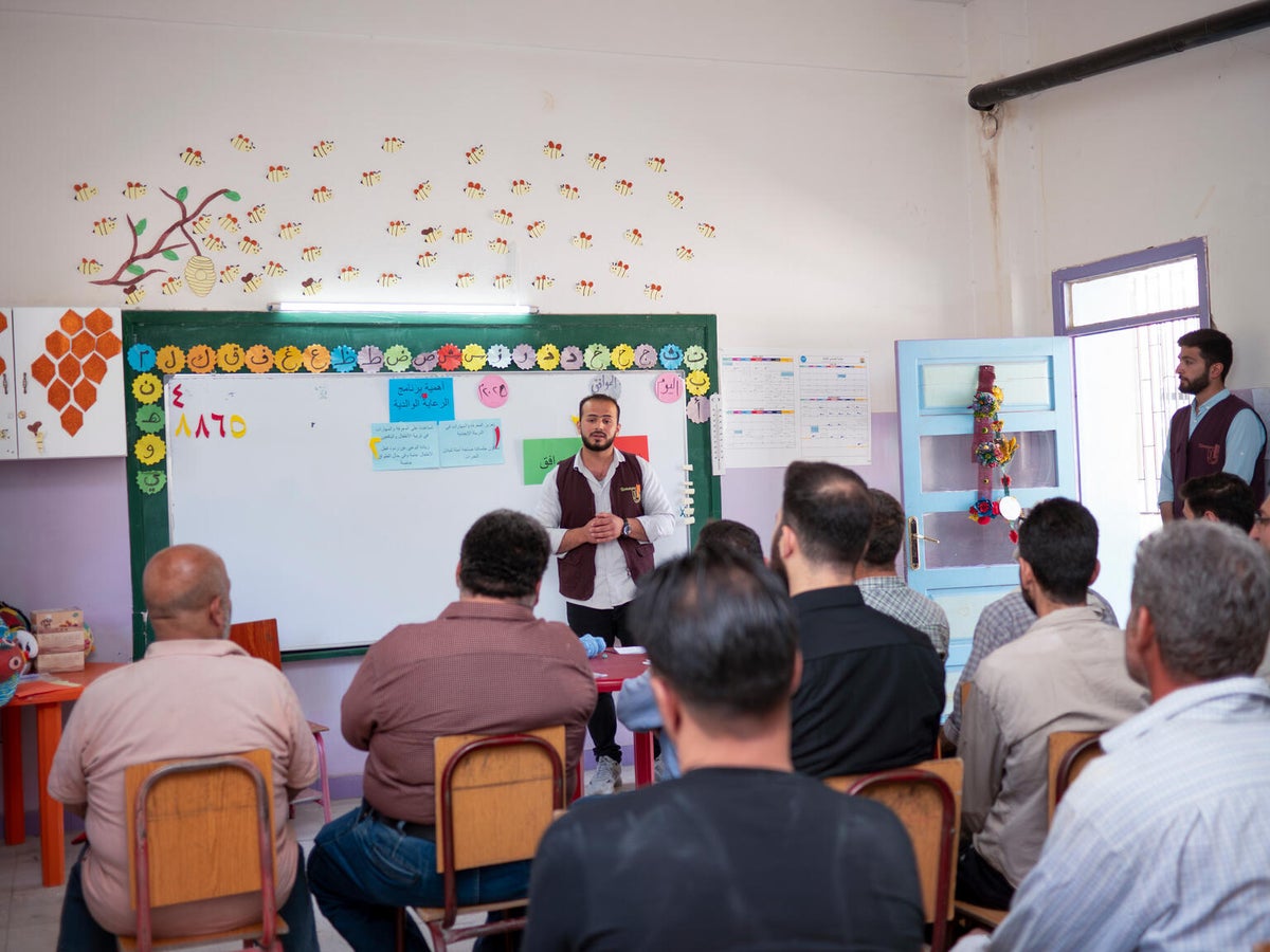 Fathers take part in a parenting session led by a UNICEF-supported child protection team at a school in Syria.