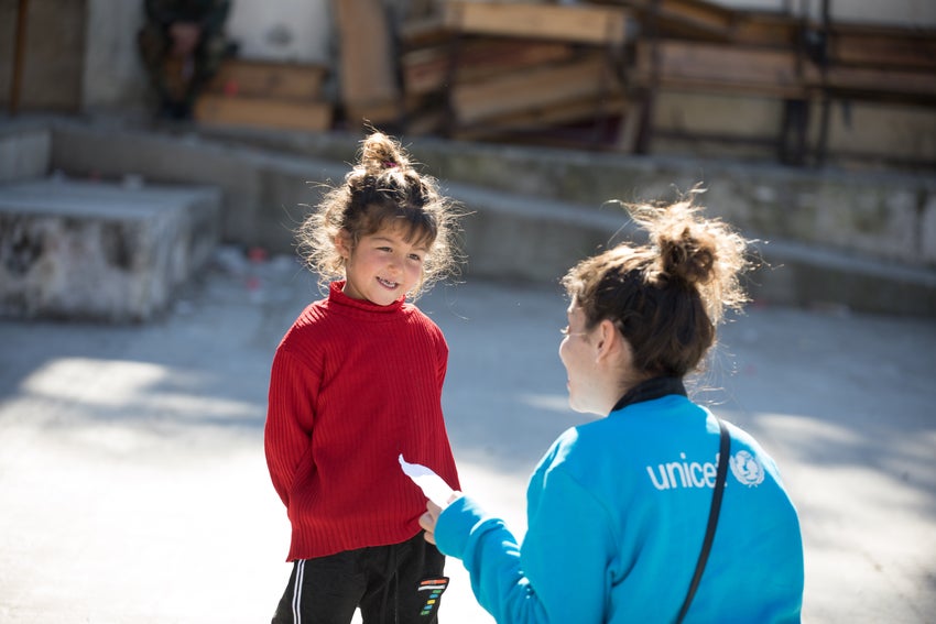 A UNICEF worker talking to a young girl.