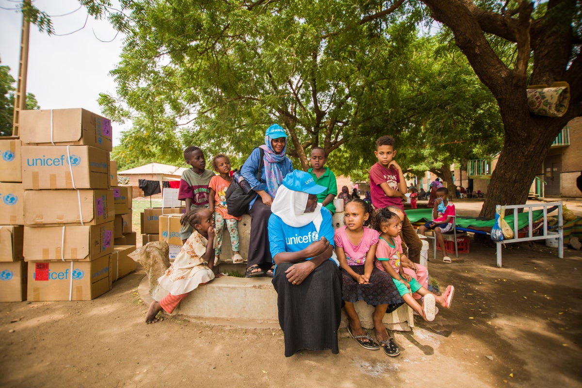 UNICEF staff delivering supplies to displaced children and families at a gathering point in Sudan