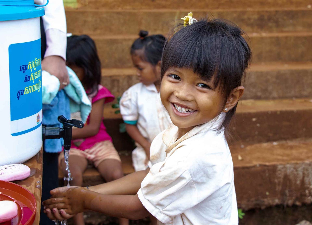  student washes her hands at school using a handwashing station supplied by UNICEF