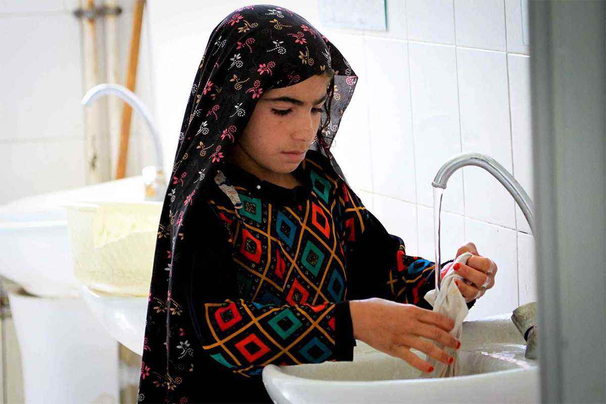 Child washing under tap