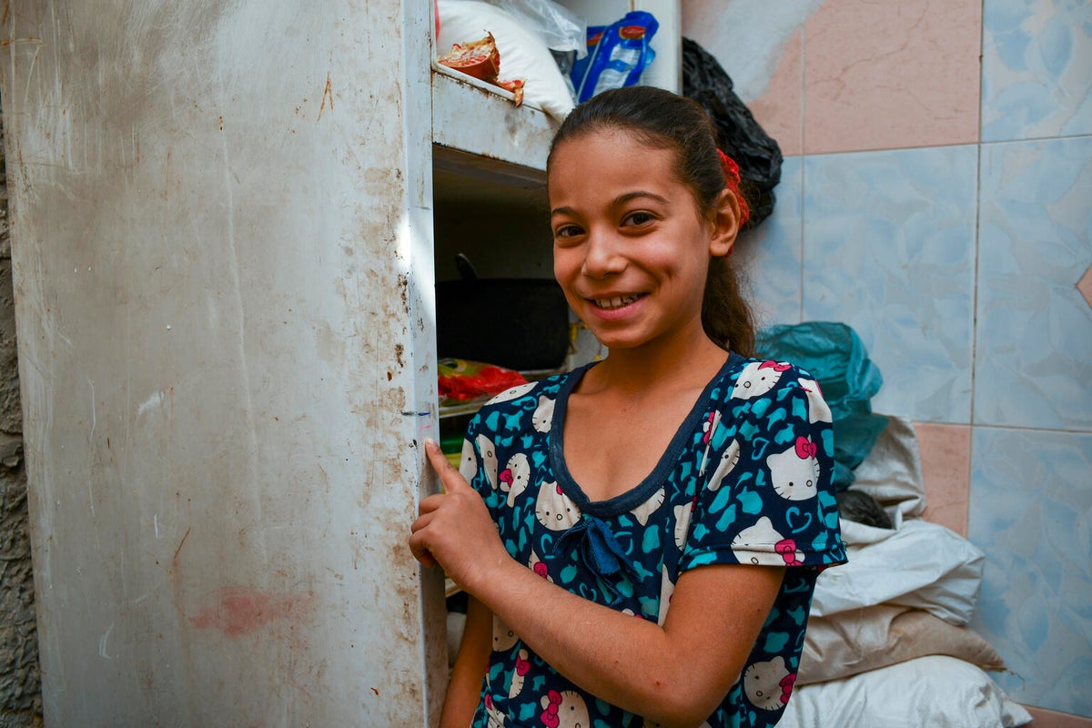 Young Syrian girl smiling at the camera from her family home.