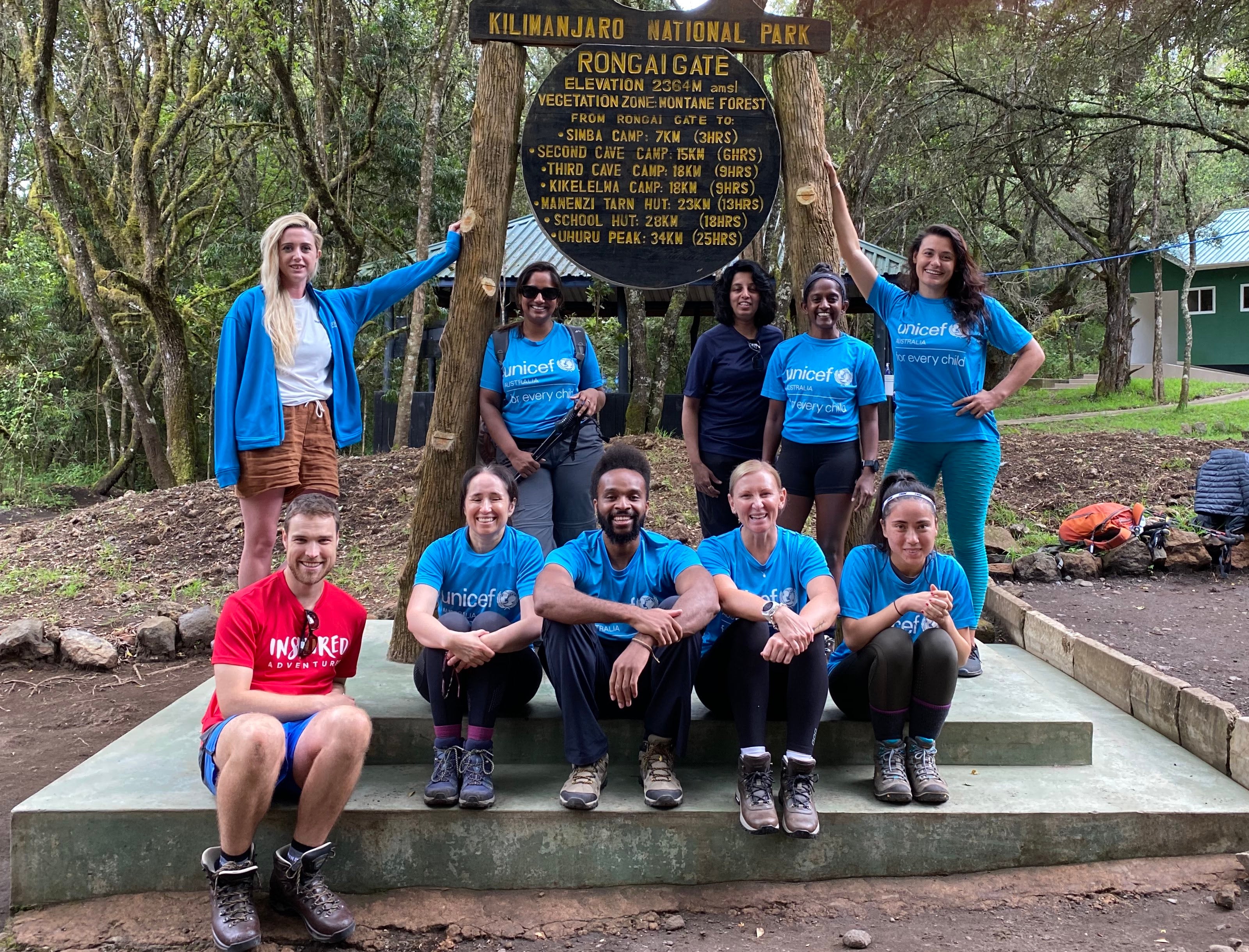A group of people with UNICEF t-shirts. They are by a Mt. Kilimanjaro sign