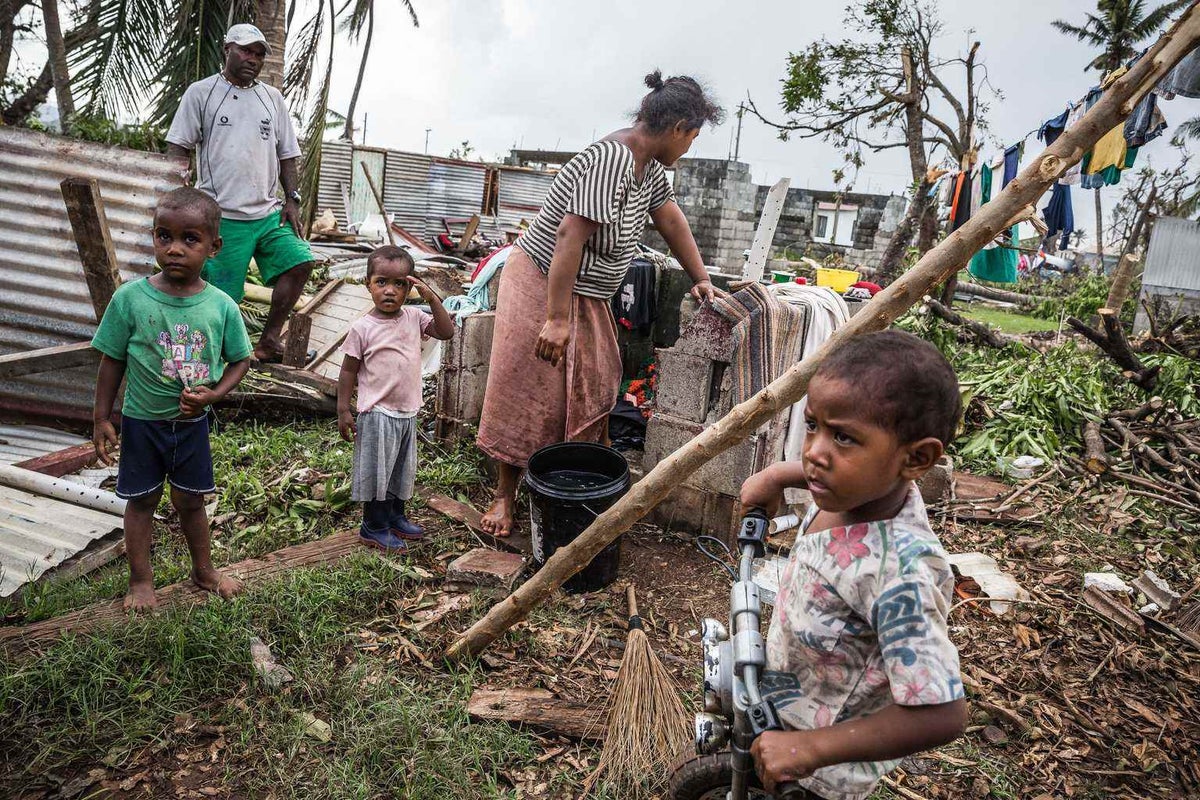 Family cleaning up after Cyclone ravages their home in Fiji.