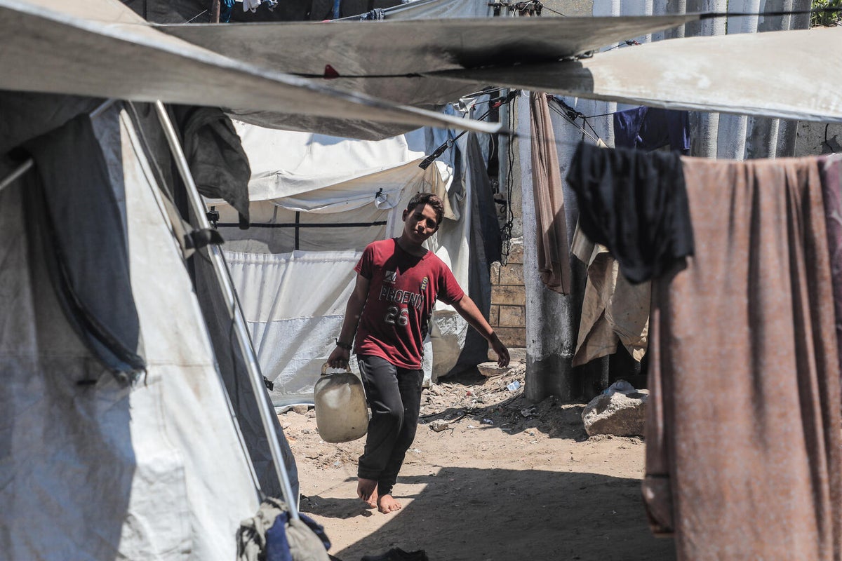 Twelve-year-old Hassan helps his family by collecting water and food from aid distribution sites.