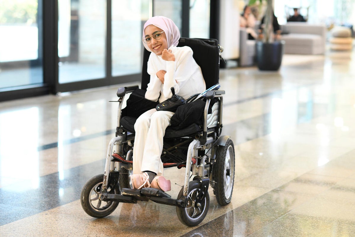 A teenage girl in a wheelchair at her school