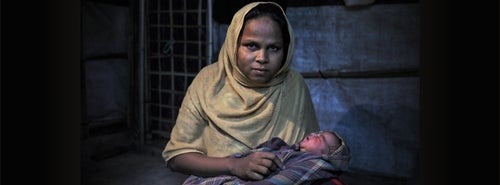 A mother cradling her newborn baby