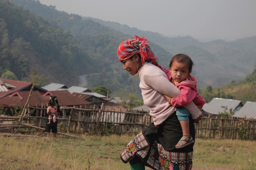 Mother carrying child on her back