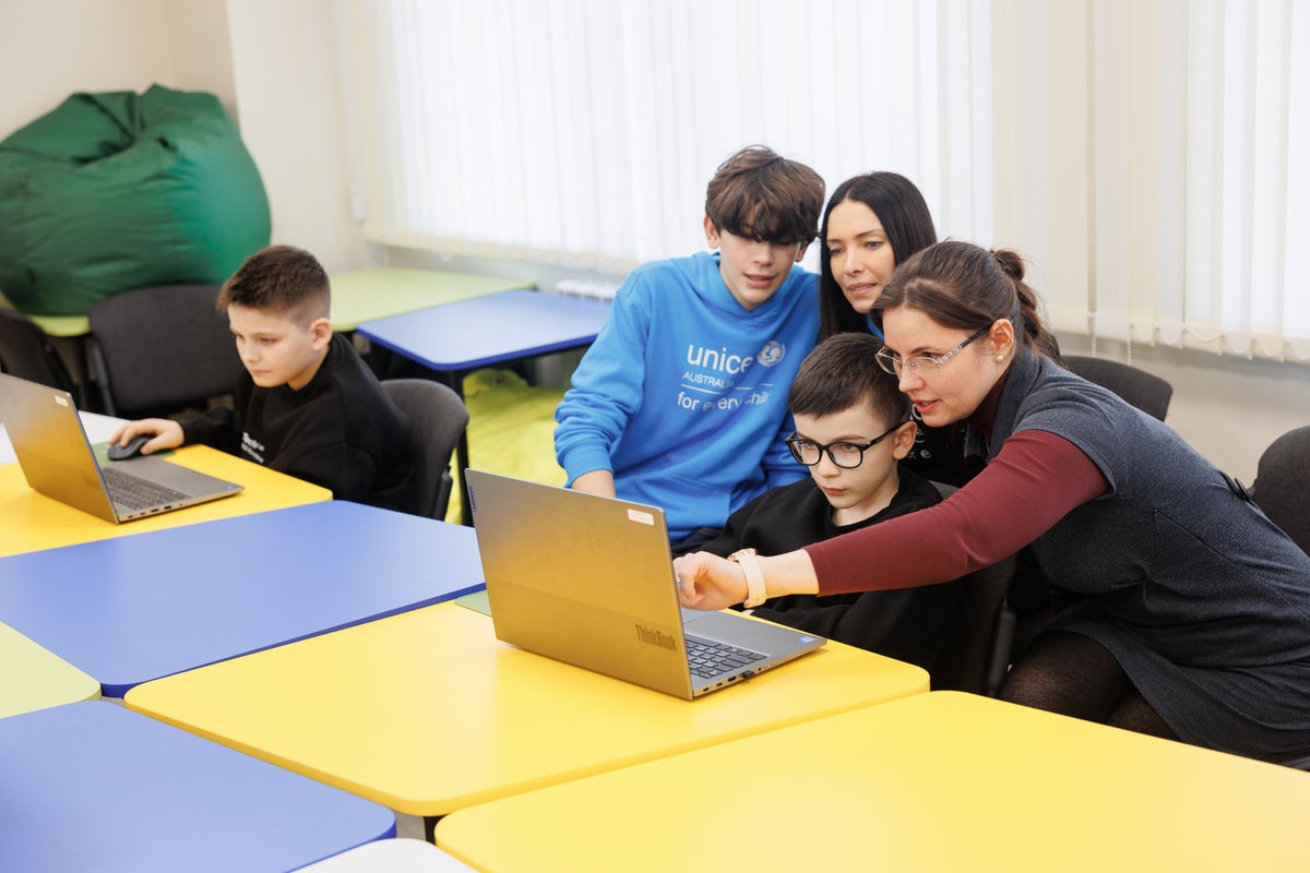 A group of students looking at a computer. 