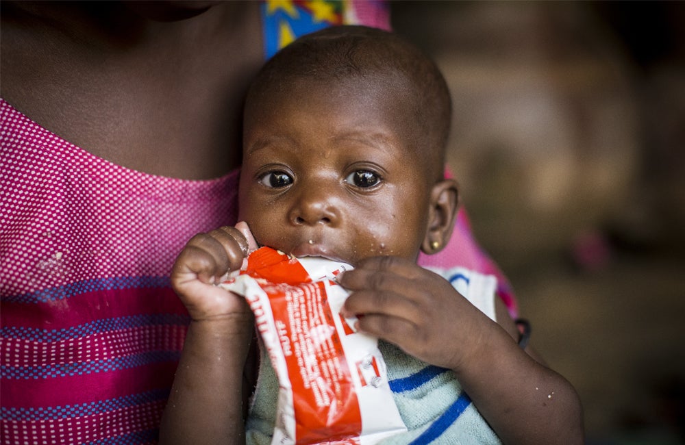 Child eats from sachet of 'Ready-to-use-therapeutic-food', packed with nutrients to treat severe acute malnutrition