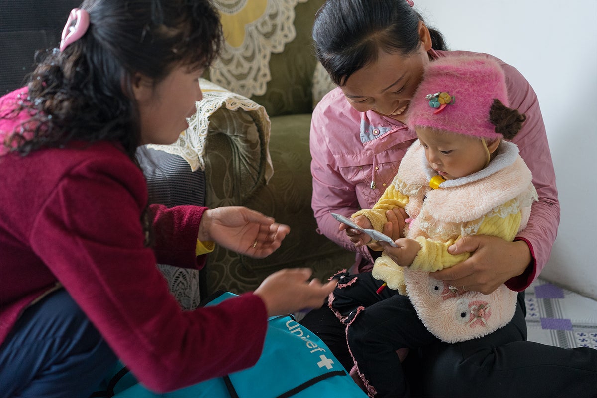 UNICEF worker gives nutritional food to an infant