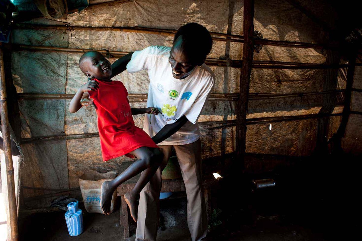 Father plays with his daughter who has recovered from malnutrition.