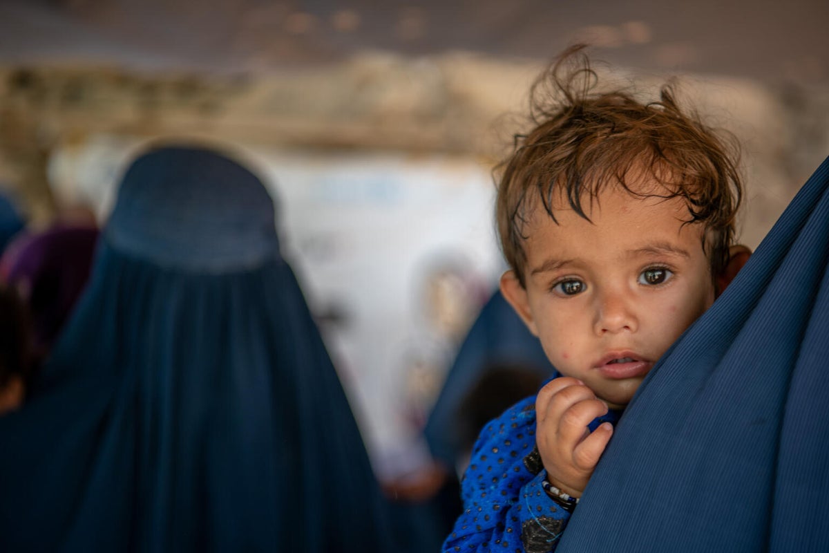 A young boy in his mum's arms in Afghanistan.