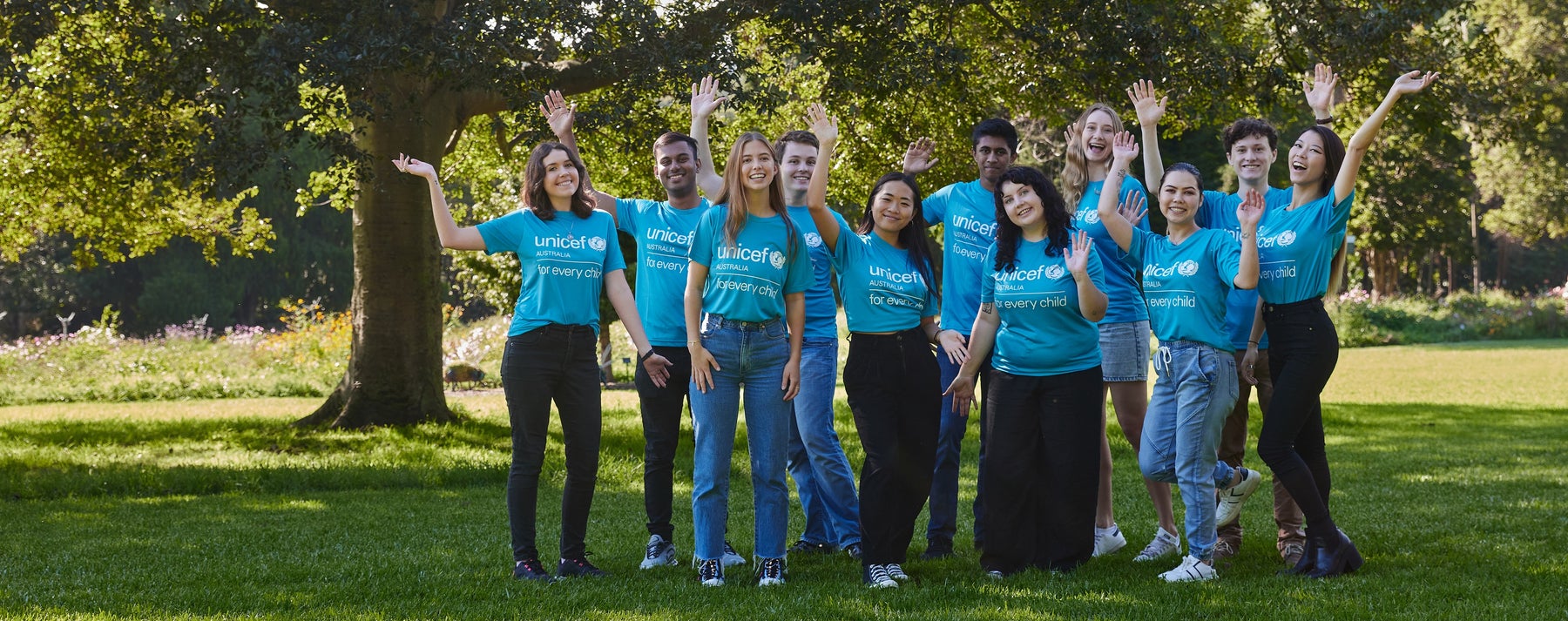 A group of 11 young people wearing UNICEF t-shirts and smiling to the camera.