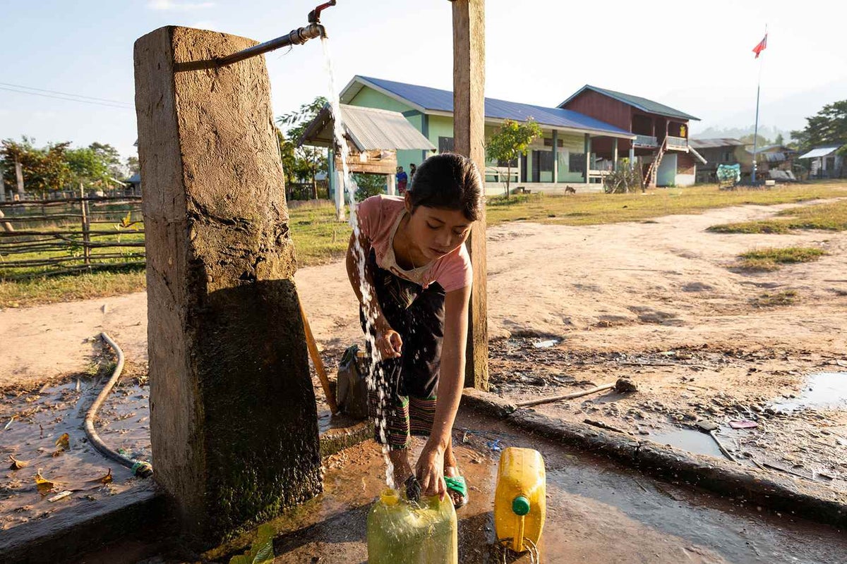 Girl filling up water cans 