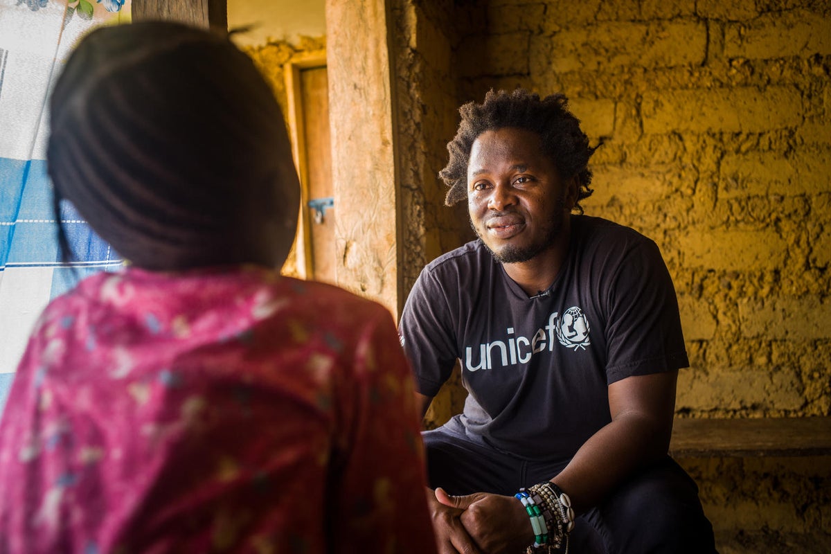 In Sierra Leone, Ishmael Beah, author, former child soldier and UNICEF Advocate for Children Affected by War, talks with a young girl who experienced violence. 