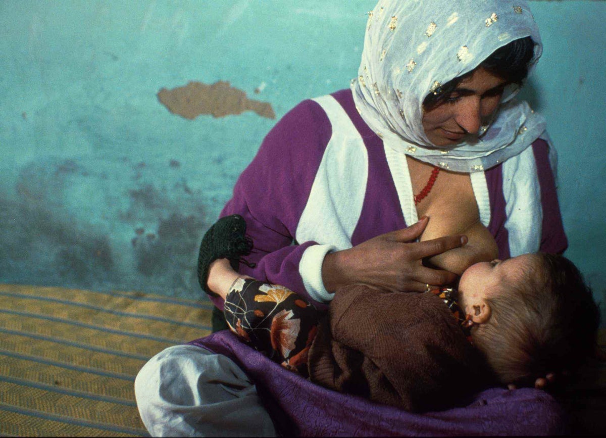 A mother breastfeeds her child at a UNICEF-supported services centre in Bagrami village, Afghanistan, 1992.
