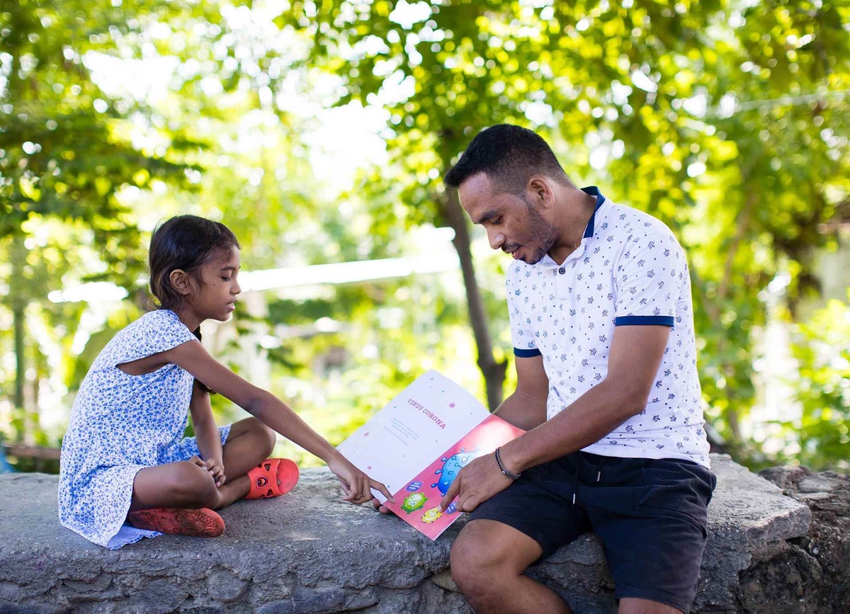 A father reads to his daughter