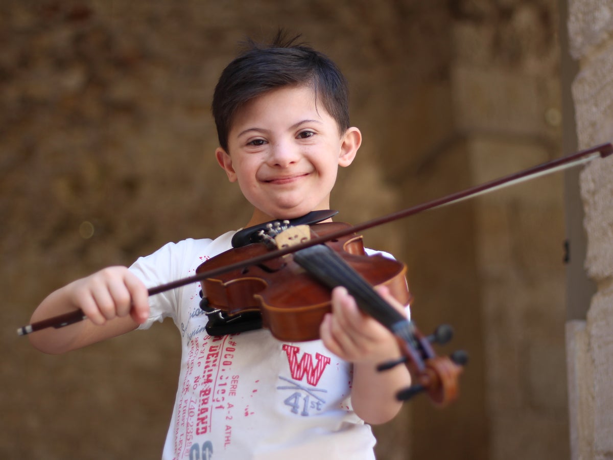 Smiling boy plays violin