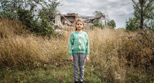 A young child stands in the streets of Ukraine.