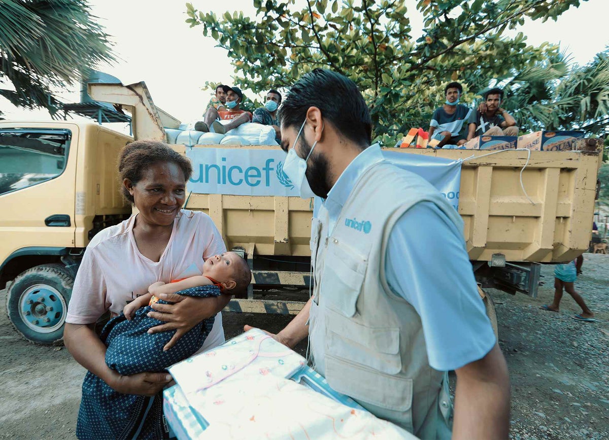 UNICEF Representative in Timor-Leste, helps a mother and her baby who have been displaced by the flooding.