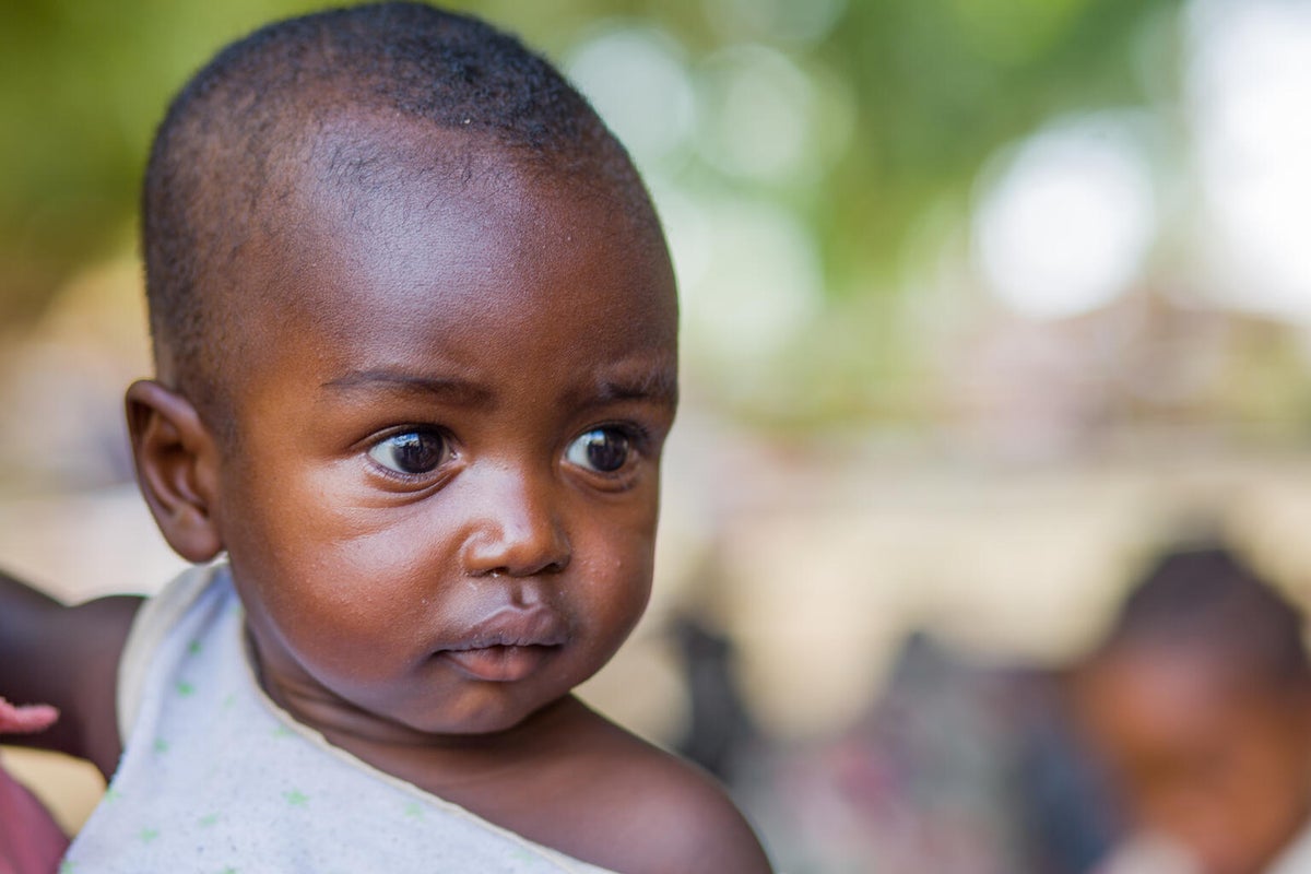 A young child being held by their parent. 