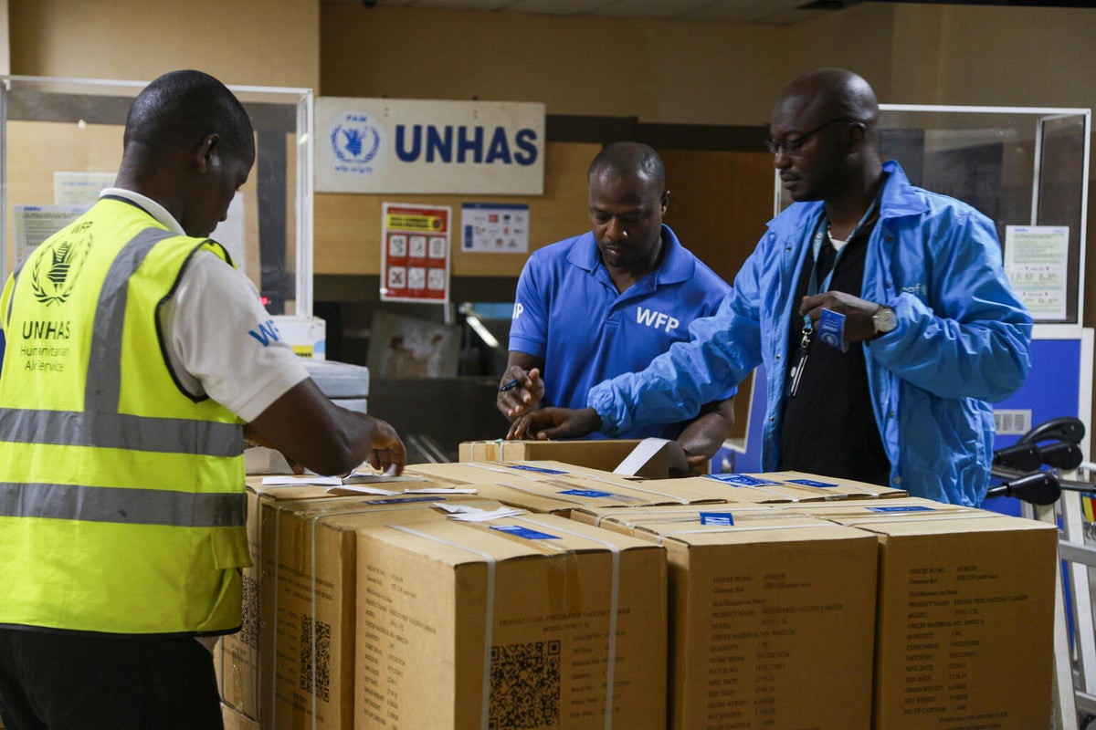 Healthcare workers inspecting a shipment of vaccines. 