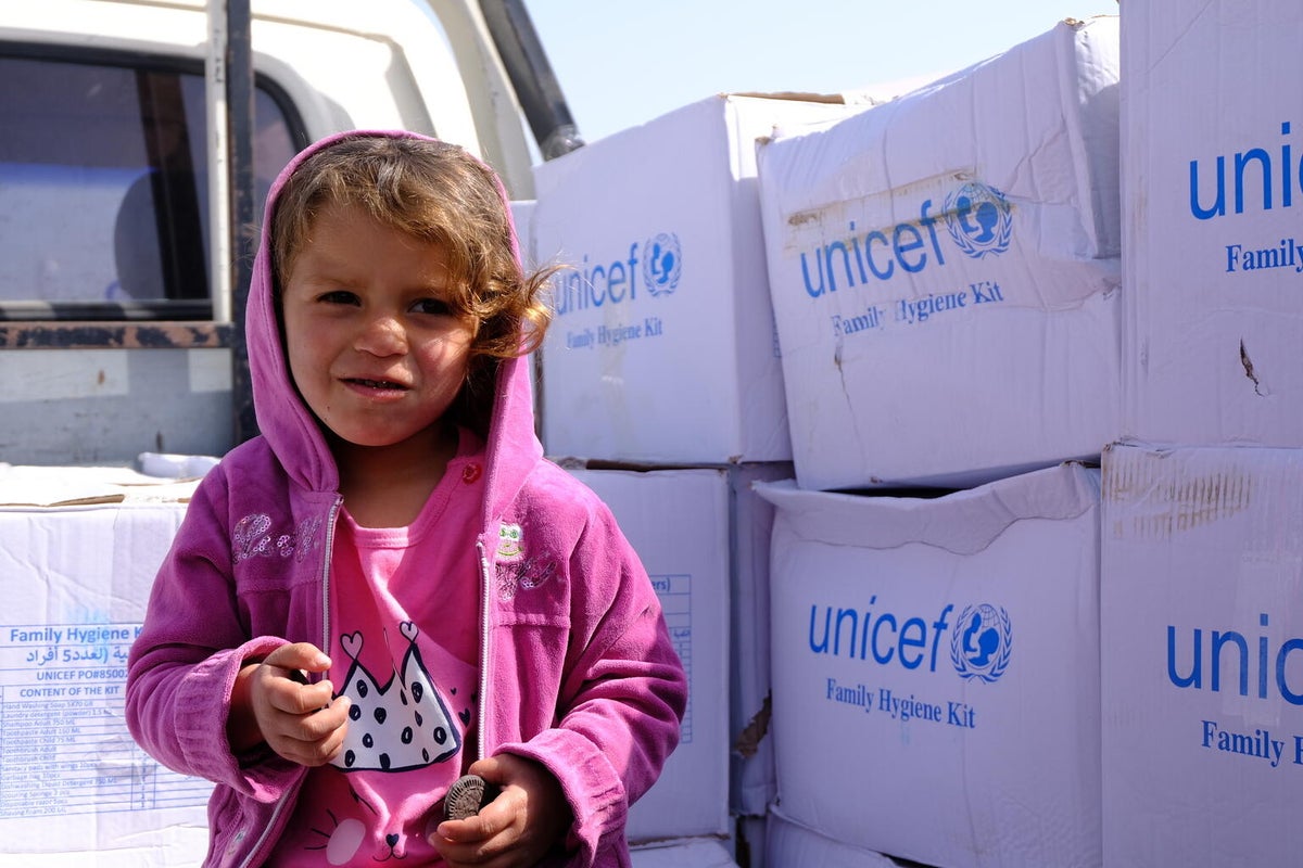 A young girl and her family receive emergency hygiene supplies in a newly established camp for internally displaced people in north-west Syria in March 2023.