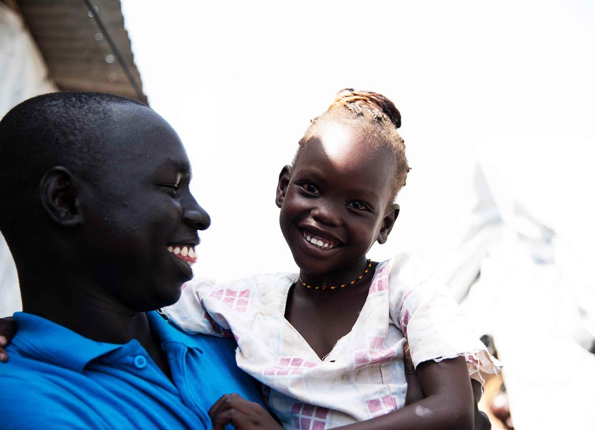 Caseworker Simon Char talks to five-year-old Nyajiper. 