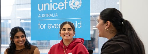 A group of three young women laugh together during a 2025 LCOY conference hosted by UNICEF Australia in Sydney. 