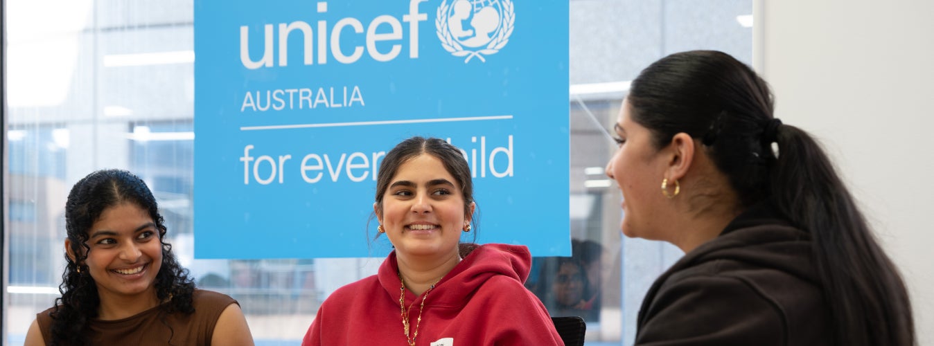 A group of three young women laugh together during a 2025 LCOY conference hosted by UNICEF Australia in Sydney.