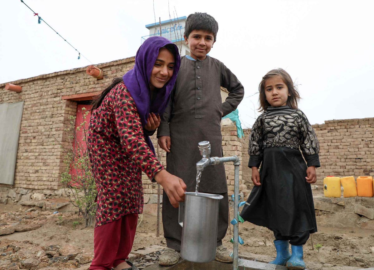 Children in Kabul collect clean water from a tap.