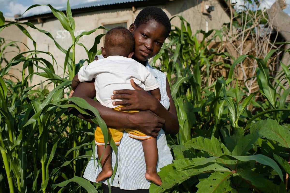 Cleara Akuliga was forced out of school in grade three due to poverty and is unsure of her age. Here, she stands with her young son in Ghana in 2015.  