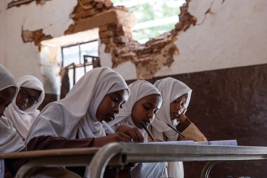 On 13 May, students attend a lesson in a partially destroyed classroom at a school in Khartoum State.