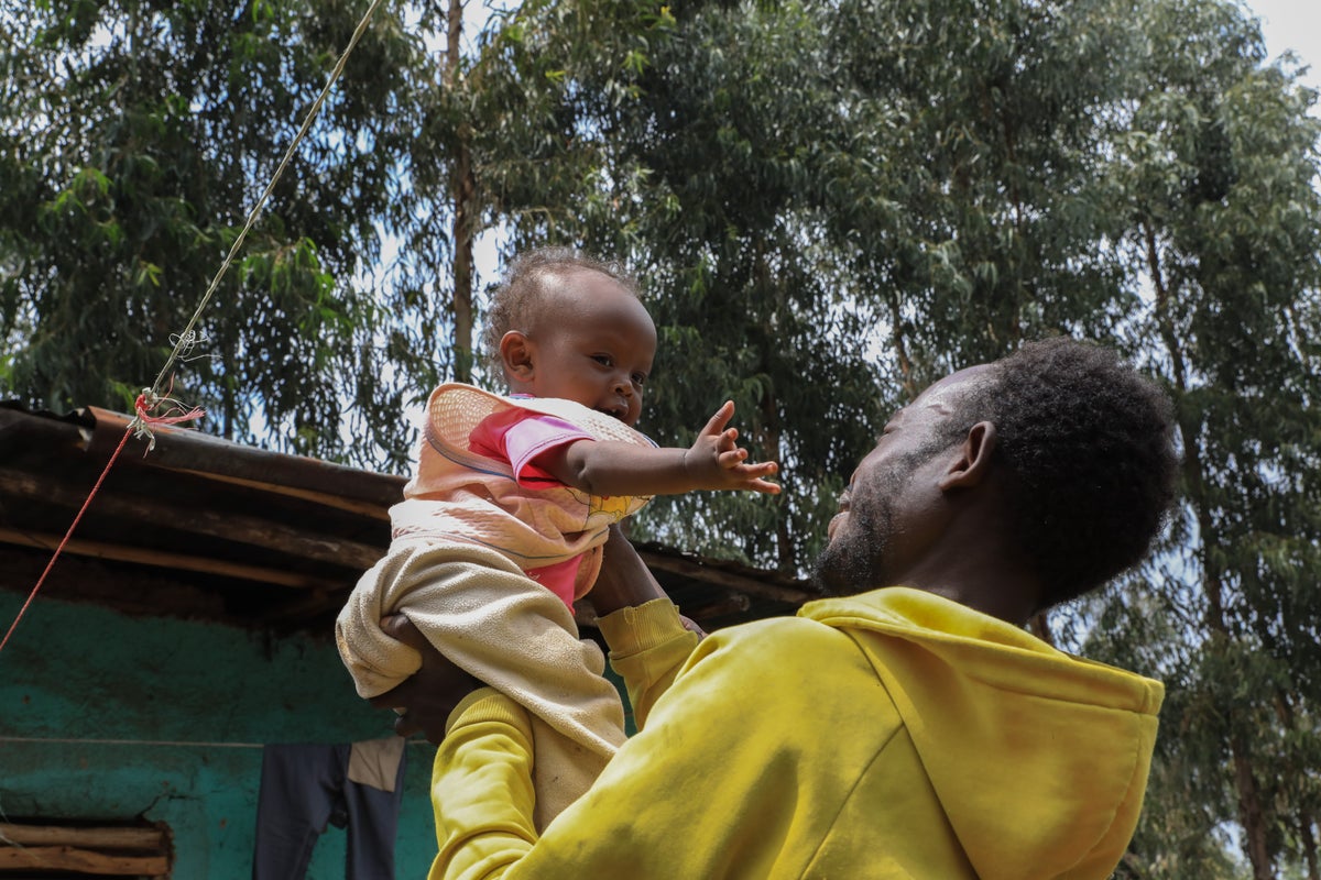 A father throws his baby playfully in the air