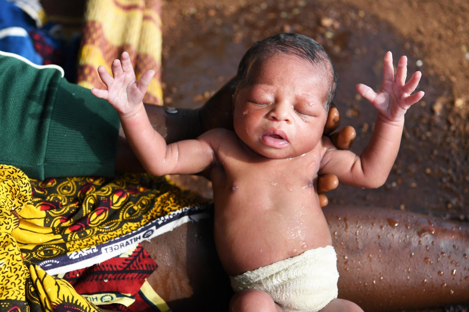 Newborn baby being washed outside the health center of Korhogo, in the North of Côte d'Ivoire.
