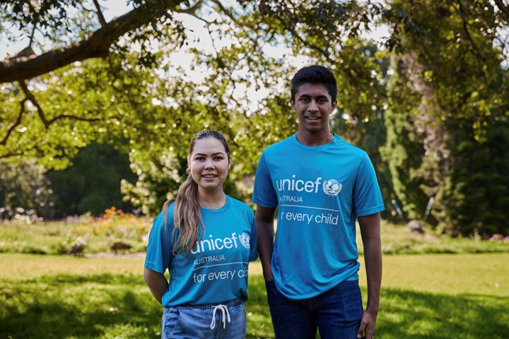 Two people in unicef shirts standing outdoors