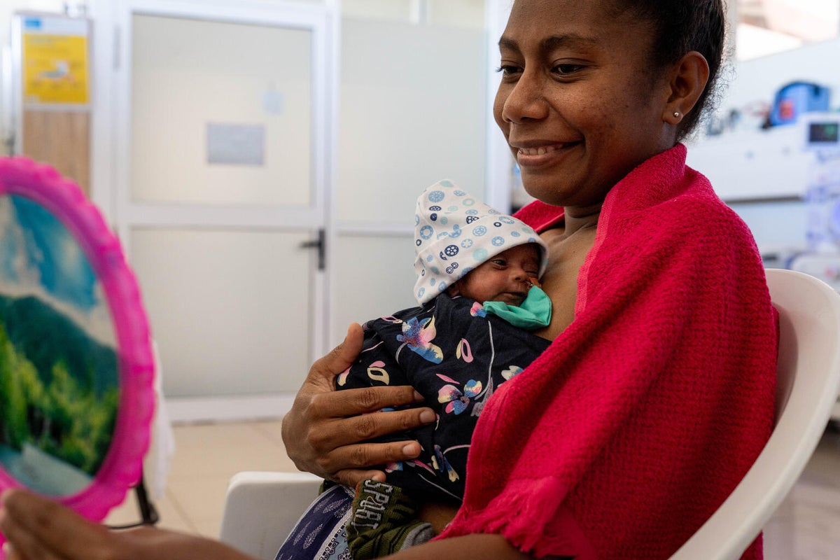 A women holding her newborn baby in her arms.