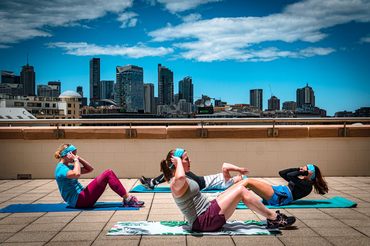 Four fundraisers completing sit ups on a balcony. 